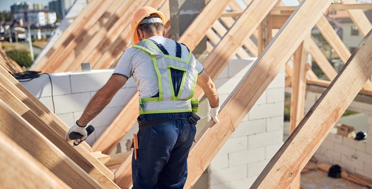 Construction professional using a tablet on-site to manage blueprints